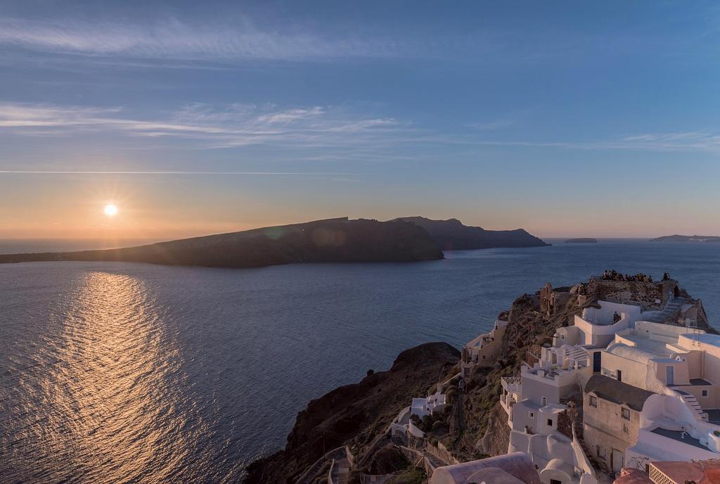 Sunset over Santorini island with white buildings and blue domes